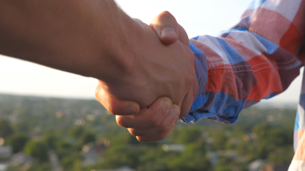 Two men shake hands